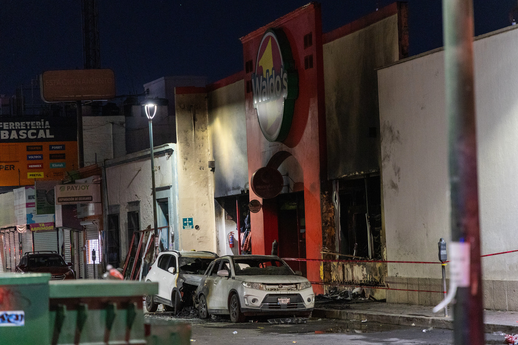 Damaged vehicles are parked in front of a convenience store destroyed by a fire, in Hermosillo, Sonora state, Mexico, Saturday, Nov. 1, 2025. (AP Photo/Abraham Tellez)