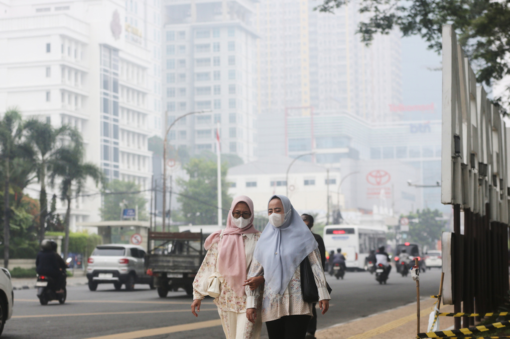 Women walk as haze from wildfires shrouds the city of Medan, North Sumatra, Indonesia, Thursday, Oct. 15, 2026. (AP Photo/Binsar Bakkara)
