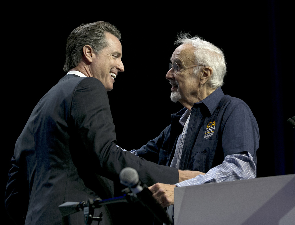 FILE - California gubernatorial candidate, Lt. Gov. Gavin Newsom, left, jokes with John Burton chairman of the California Democratic Party, before addressing the California Democratic Party Convention, Saturday, May 20, 2017, in Sacramento, Calif. (AP Photo/Rich Pedroncelli,File)
