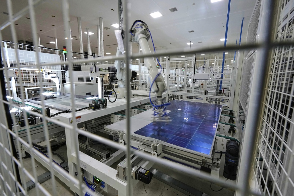 A robot places solar cells on a glass panel at a ReNew manufacturing plant on the outskirts of Jaipur, India, Thursday, Aug. 21, 2025. (AP Photo/Manish Swarup)