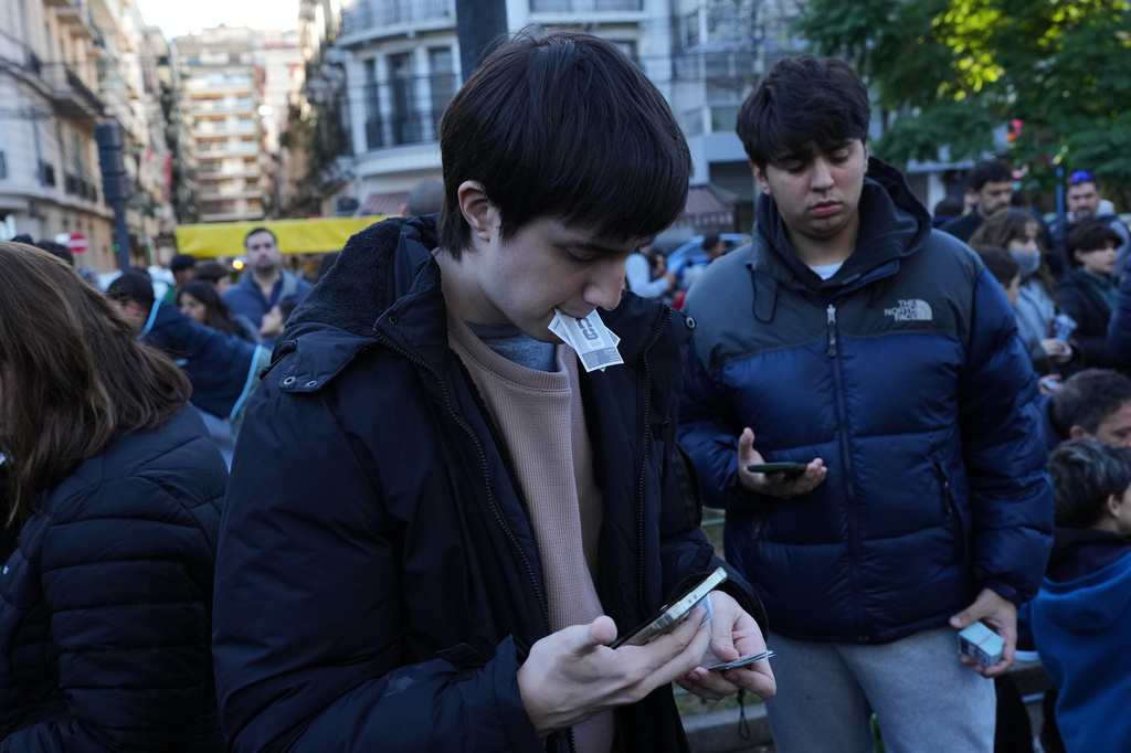 People gather at a square to exchange collectible stickers for the 2026 FIFA World Cup soccer albums in Buenos Aires, Argentina, Sunday, May 10, 2026. (AP Photo/Rodrigo Abd)