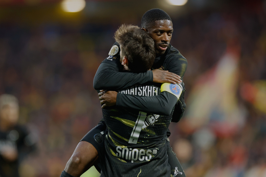 Khvicha Kvaratskhelia del Paris Saint-Germain celebra con su compañero Ousmane Dembele tras anotar un gol ante Lens en la liga francesa, el miércoles 13 de mayo de 2026. (AP Foto/Jean-Francois Badias)