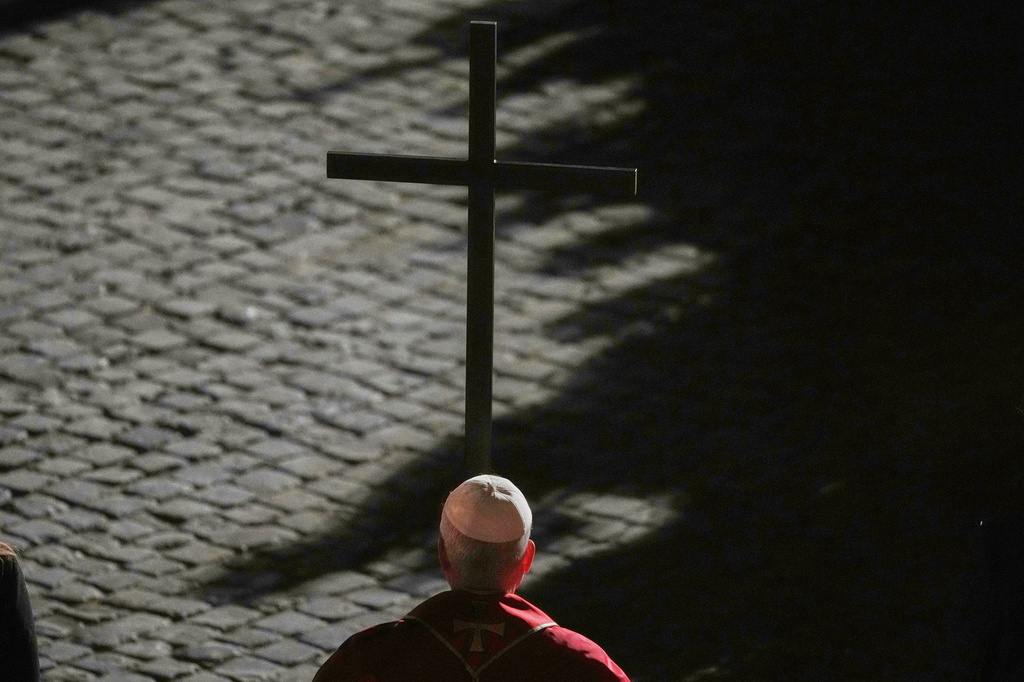 Pope Leo XIV carries a lightweight, 1.5-meter (5-foot) wooden cross during the Via Crucis, the torchlit Good Friday Stations of the Cross procession at the Colosseum in Rome, Friday, April 3, 2026, which symbolically retraces Jesus Christ's steps to his crucifixion on Calvary in Jerusalem. (AP Photo/Alessandra Tarantino)