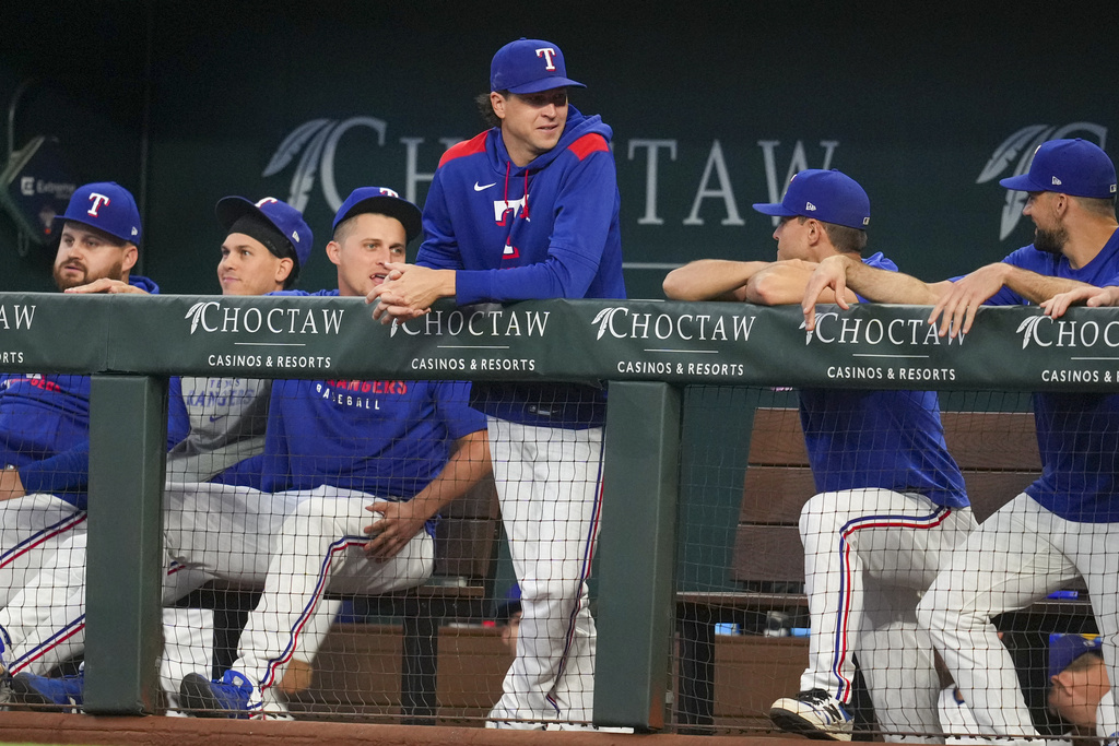 Texas Rangers pitcher Jacob deGrom, standing, is seen in the dugout with teammates prior to a baseball game against the Milwaukee Brewers Wednesday, Sept. 10, 2025, in Arlington, Texas. (AP Photo/Julio Cortez)