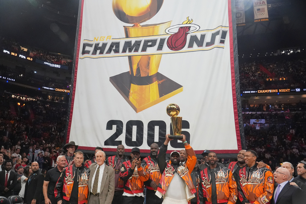The Miami Heat 2006 NBA championship team pose with the trophy during a half time celebration Tuesday, Feb. 3, 2026, in Miami. (AP Photo/Marta Lavandier)