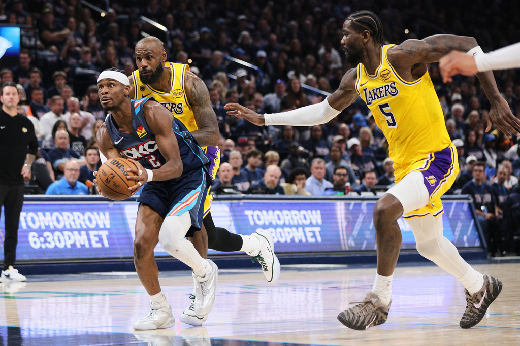 Oklahoma City Thunder guard Shai Gilgeous-Alexander (2) drives to the basket past Los Angeles Lakers' Deandre Ayton (5) and LeBron James, rear, in the second half of Game 2 in a second-round NBA basketball playoffs series Thursday, May 7, 2026, in Oklahoma City. (AP Photo/Nate Billings)