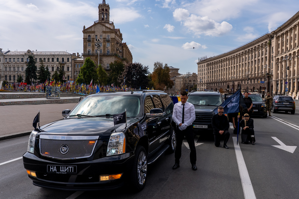 Family and friends pay their respect to soldier Danyil Smyrnov, 21, who was killed on the frontline, during the minute of silence on Independence Square, Kyiv, Ukraine, Thursday, Sept. 3, 2026. (AP Photo/Alex Babenko)