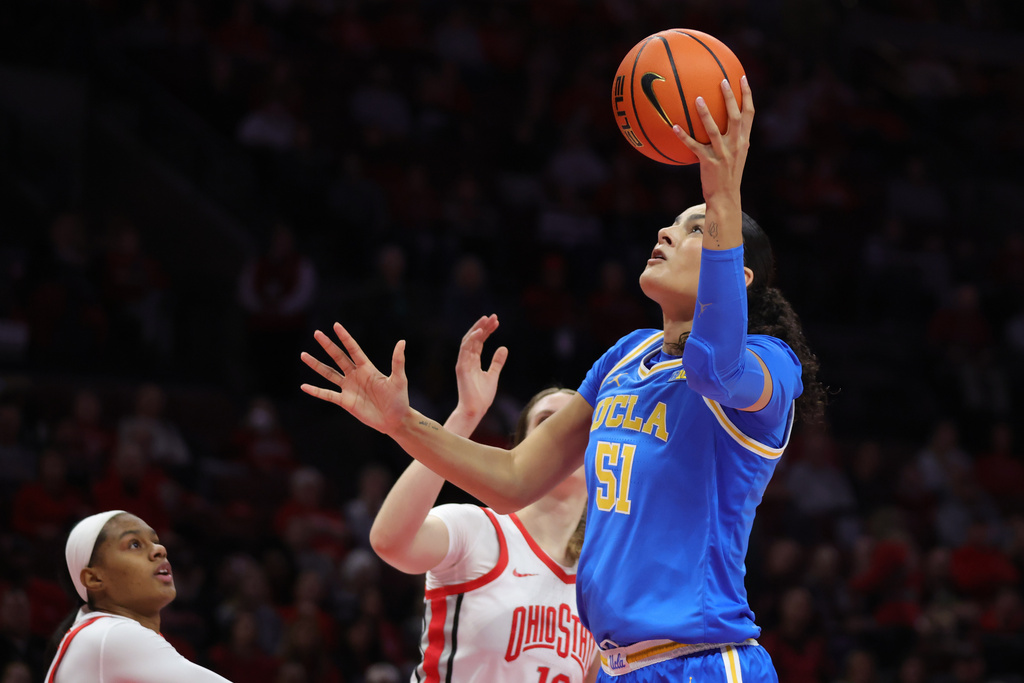 UCLA center Lauren Betts, right, shoots in front of Ohio State center Elsa Lemmila, center, and guard Kennedy Cambridge, left, during the first half of an NCAA college basketball game in Columbus, Ohio, Sunday, Dec. 28, 2025. (AP Photo/Paul Vernon)