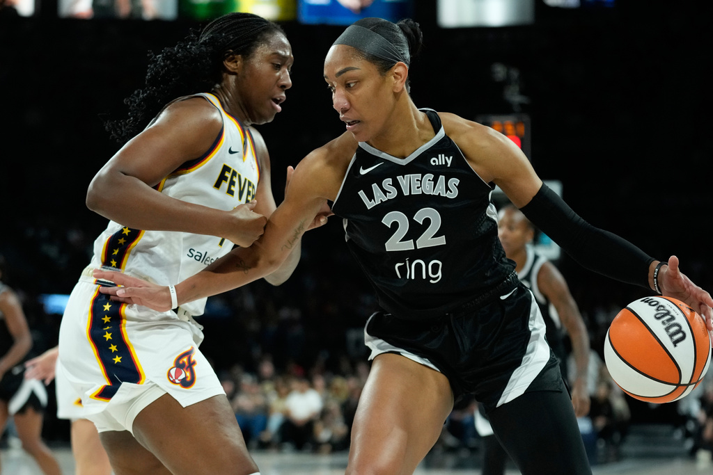 Las Vegas Aces center A'ja Wilson (22) drives against Indiana Fever forward Aliyah Boston (7) during the first half of Game 5 of a WNBA basketball playoff semifinals series Tuesday, Sept. 30, 2025, in Las Vegas. (AP Photo/John Locher)