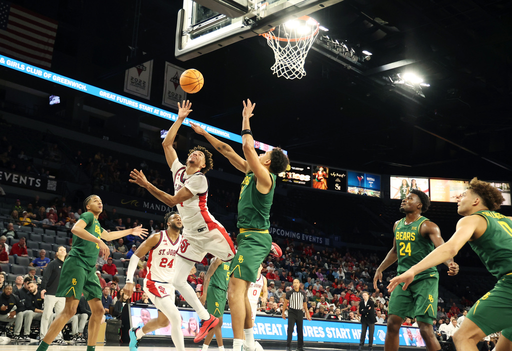 St. John's guard Oziyah Sellers (4) goes for a shot around Baylor guard Michael Rataj (12) during the first half of an NCAA college basketball game Tuesday, Nov. 25, 2025, in Las Vegas. (AP Photo/Ronda Churchill)