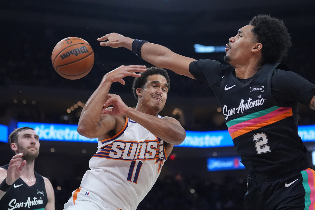 San Antonio Spurs guard Dylan Harper (2) knocks the ball away from Phoenix Suns forward Oso Ighodaro (11) during the first half of an NBA basketball game in Austin, Texas, Thursday, Feb. 19, 2026. (AP Photo/Eric Gay)