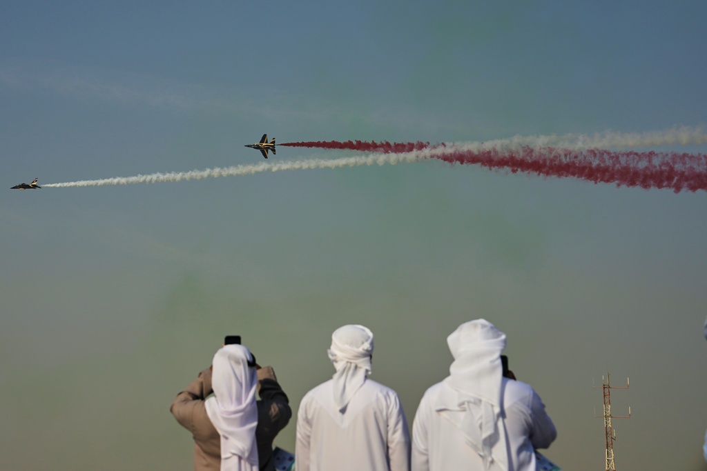 Emirati men take photos of Fursan Al Emarat, the aerobatics demonstration team of the United Arab Emirates Air Force during the Dubai Air Show in Dubai, United Arab Emirates, Tuesday, Nov. 18, 2025. (AP Photo/Fatima Shbair)