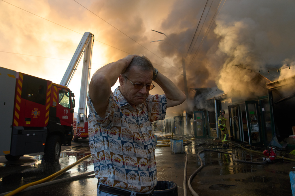 FILE - Bookseller Alexander Bahlai reacts as firefighters try to put out a fire at a city book market following a Russian missile attack in Kyiv, Ukraine, Aug. 16, 2026. (AP Photo/Francisco Seco)