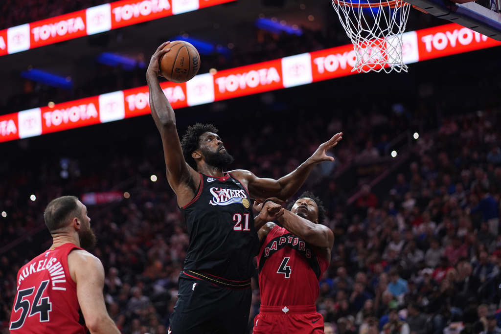 Philadelphia 76ers' Joel Embiid (21) goes up for a shot against Toronto Raptors' Scottie Barnes (4) during the first half of an NBA basketball game Saturday, Nov. 8, 2025, in Philadelphia. (AP Photo/Matt Slocum)