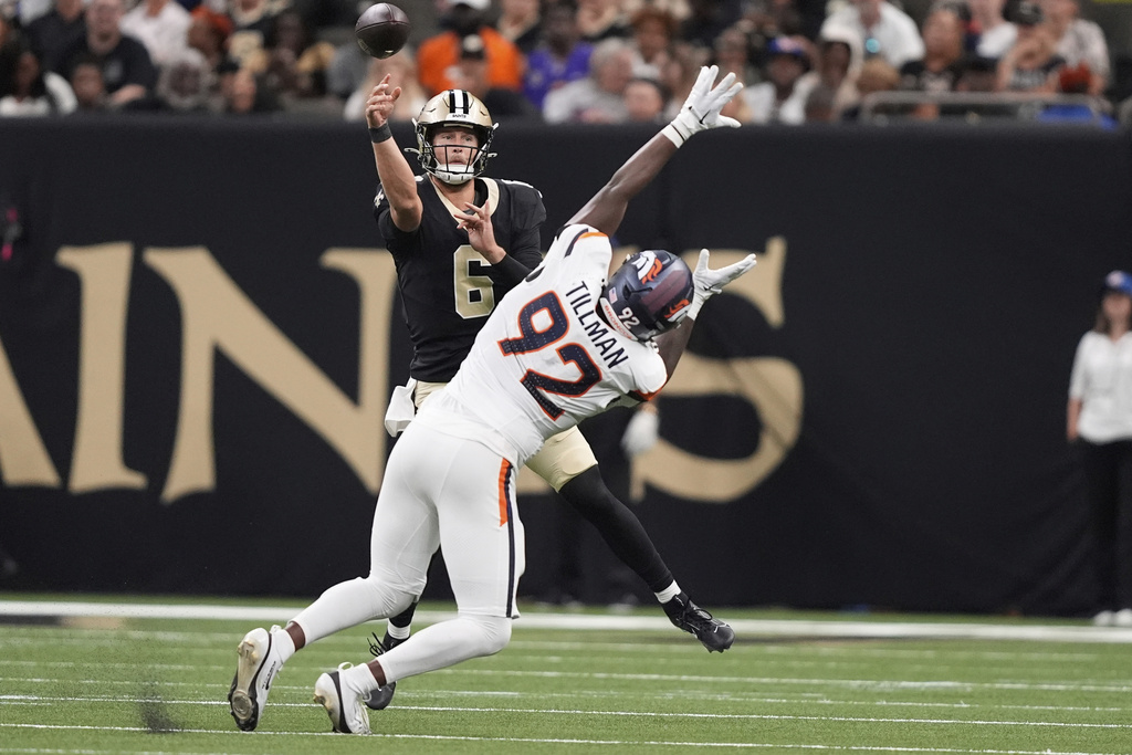 New Orleans Saints quarterback Tyler Shough, back, throws a pass as Denver Broncos linebacker Dondrea Tillman pursues in the first half of an NFL preseason football game Saturday, Aug. 23, 2025, in New Orleans. (AP Photo/Gerald Herbert)