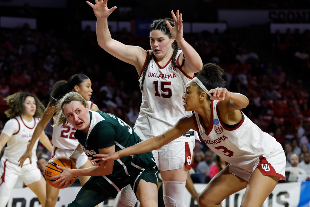 Michigan State guard Kennedy Blair, front left, is defended by Oklahoma center Raegan Beers (15) and guard Zya Vann (3) during the first half in the second round of the NCAA college basketball tournament, Sunday, March 22, 2026, Norman, Okla. (AP Photo/Alonzo Adams)