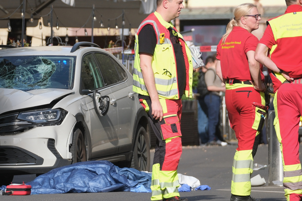Rescue workers stand next to a damaged car that has crashed into several people in Leipzig, Germany, Monday, May 4, 2026. (Sebastian Willnow/dpa via AP)