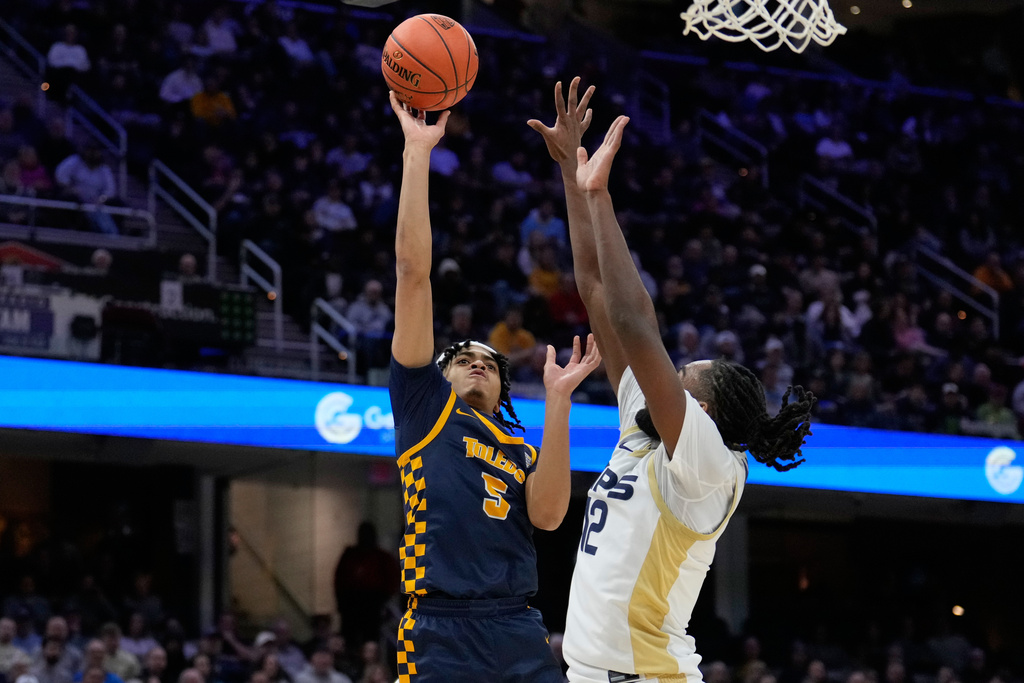 Toledo guard Mynor Strong (5) shoots as Akron guard Evan Mahaffey (12) defends in the first half of an NCAA college basketball game in the championship of the Mid-American Conference tournament, Saturday, March 14, 2026, in Cleveland. (AP Photo/Sue Ogrocki)