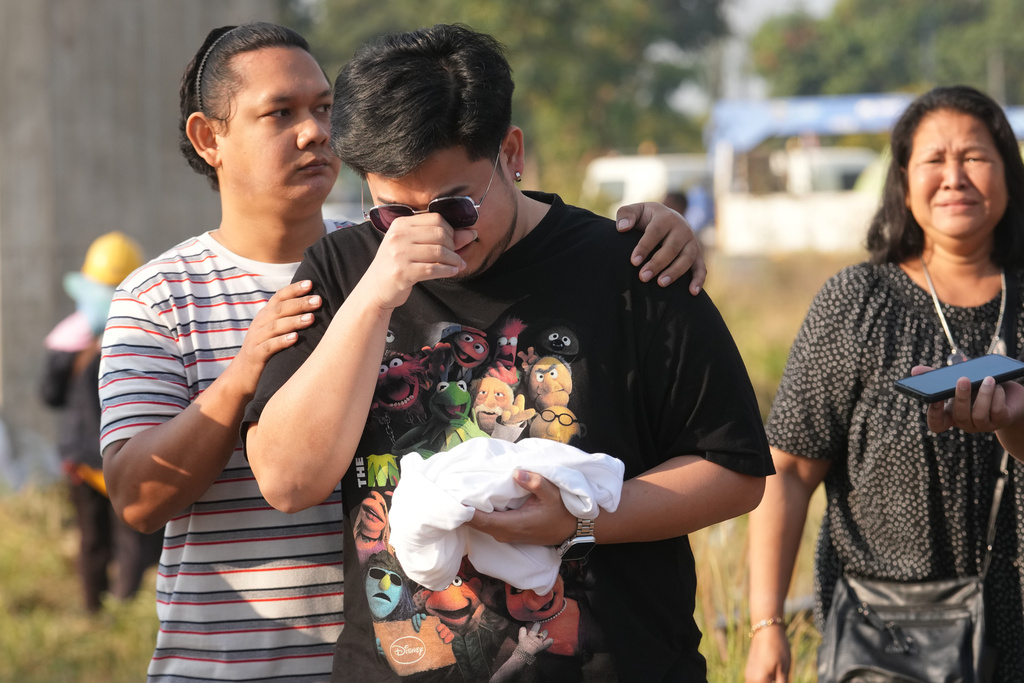 Relatives of the victims react near the site where a construction crane fell into a passenger train on Wednesday, in Nakhon Ratchasima province, Thailand, Thursday, Jan. 15, 2026. (AP Photo/Sakchai Lalit)