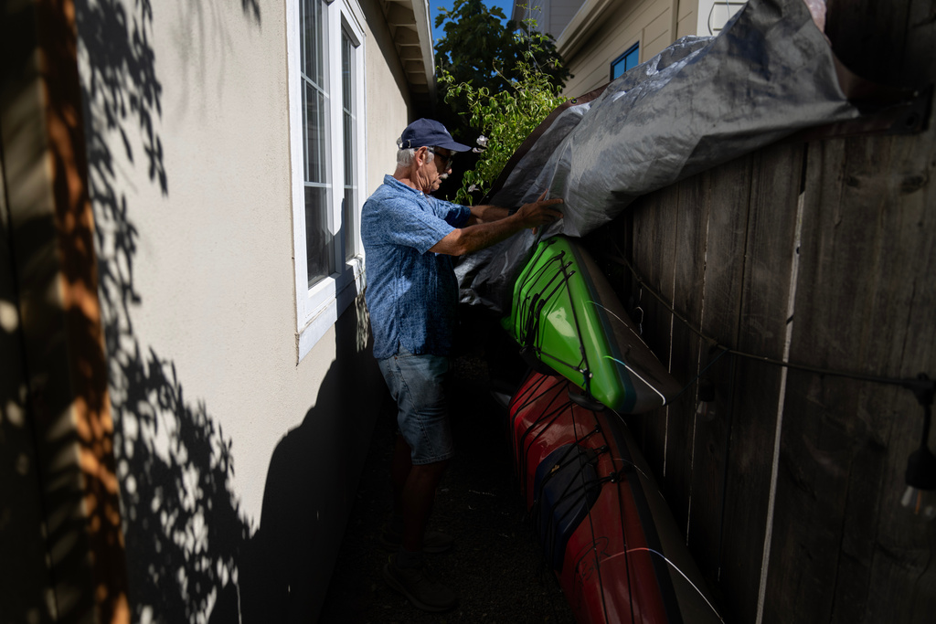 Christy Morrill, who had to give up kayaking for a time when he was experiencing seizures from autoimmune encephalitis, prepares to pack for a trip from his home, Monday, Aug. 18, 2025, in San Carlos, Calif. (AP Photo/David Goldman)