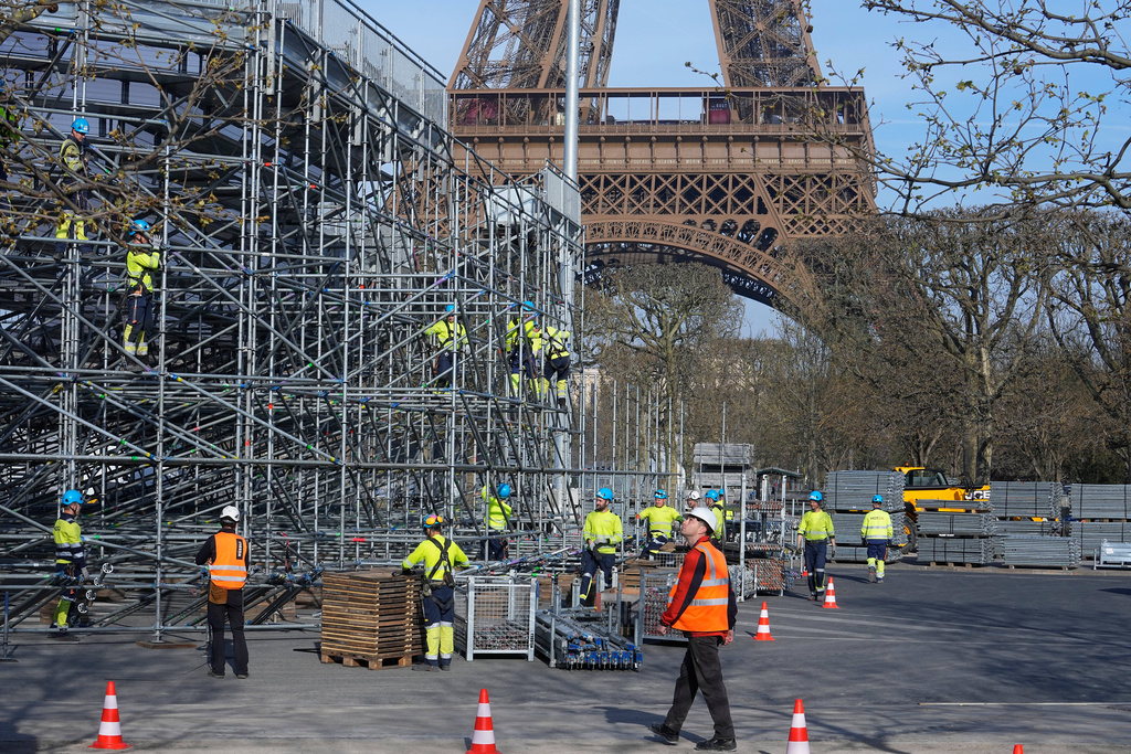 FILE - Workers build the stands for the 2024 summer Olympic Games on the Champ-de-Mars, just beside the Eiffel Tower, March 22, 2024, in Paris. (AP Photo/Michel Euler, File)