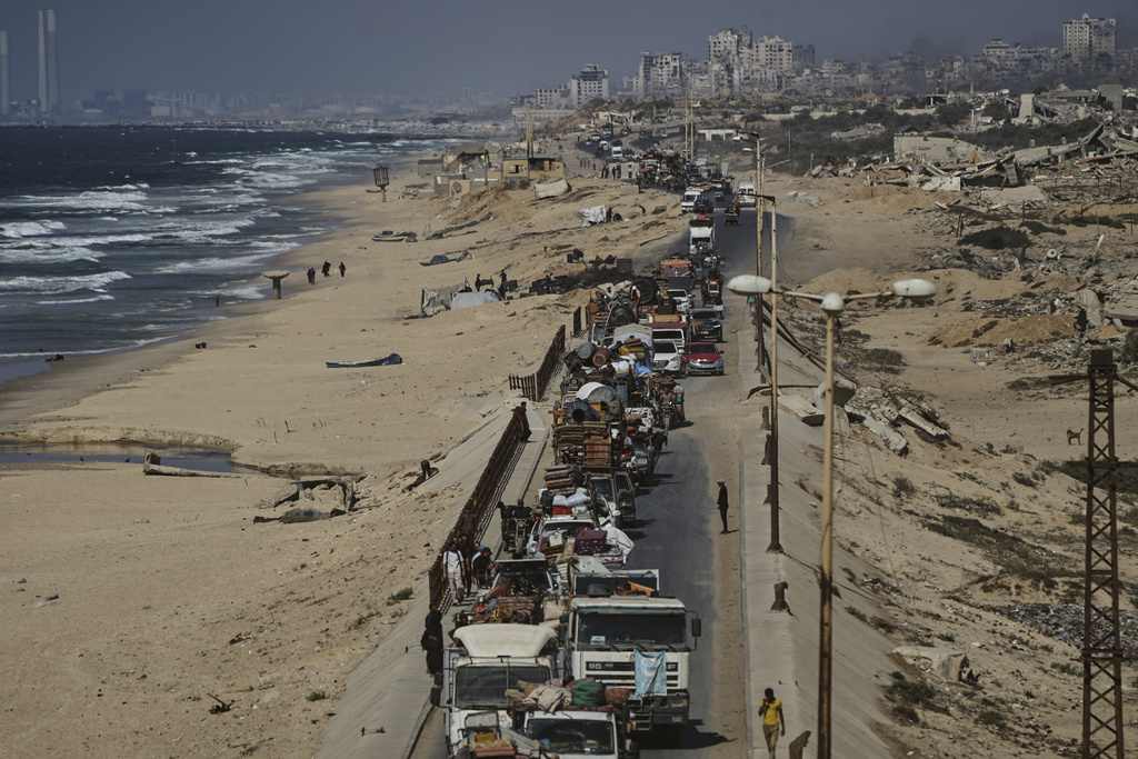Displaced Palestinians fleeing northern Gaza carry their belongings along the coastal road toward southern Gaza, Tuesday, Sept. 9, 2025, after the Israeli army issued evacuation orders from Gaza City. (AP Photo/Jehad Alshrafi)