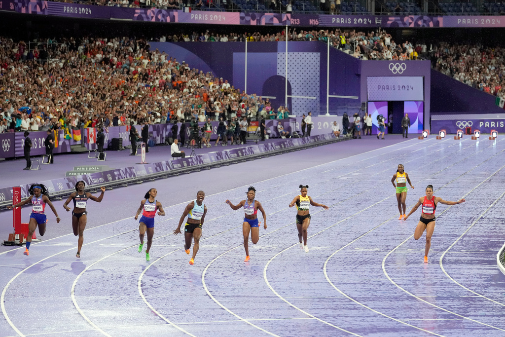 FILE - Julien Alfred, of Saint Lucia, 4th left, crosses the finish line ahead of Sha'carri Richardson, of the United States, and Melissa Jefferson, of the United States, to win the women's 100 meters final at the 2024 Summer Olympics, Saturday, Aug. 3, 2024, in Saint-Denis, France. (AP Photo/Martin Meissner, file)