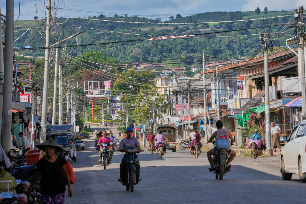 In this photo taken during a trip supervised by pro-military Myanmar media, locals ride motorbikes in Kyaukme, northern Shan State, Myanmar, Friday, Oct. 10, 2025. (AP Photo/Aung Shine Oo)