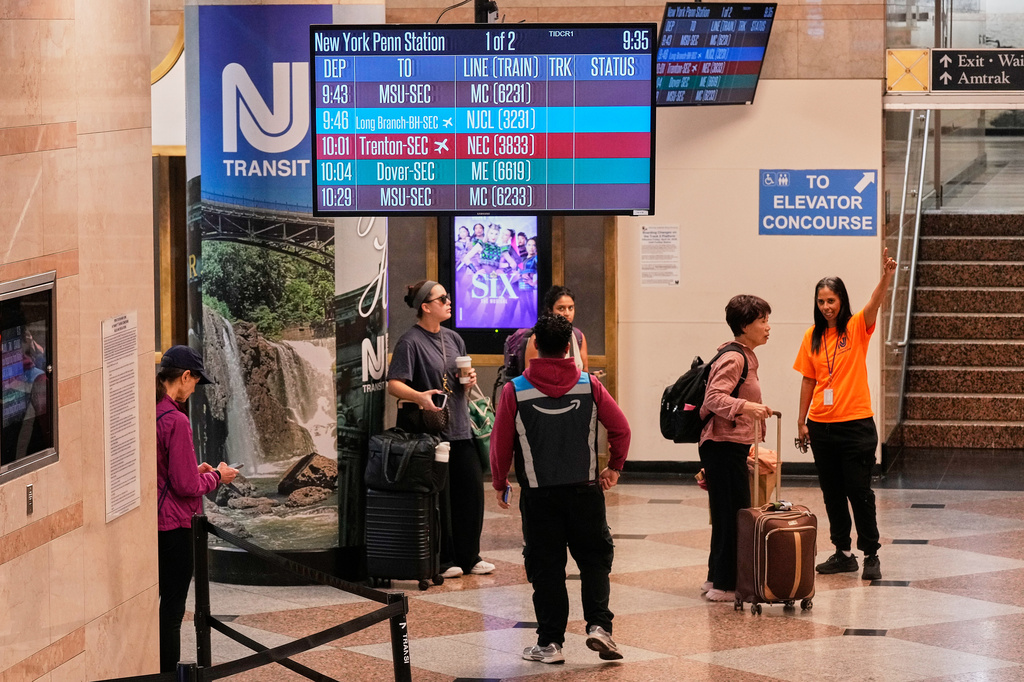 A New Jersey Transit employee, right, directs passengers in New York's Penn Station, Friday, May 29, 2026. (AP Photo/Richard Drew)