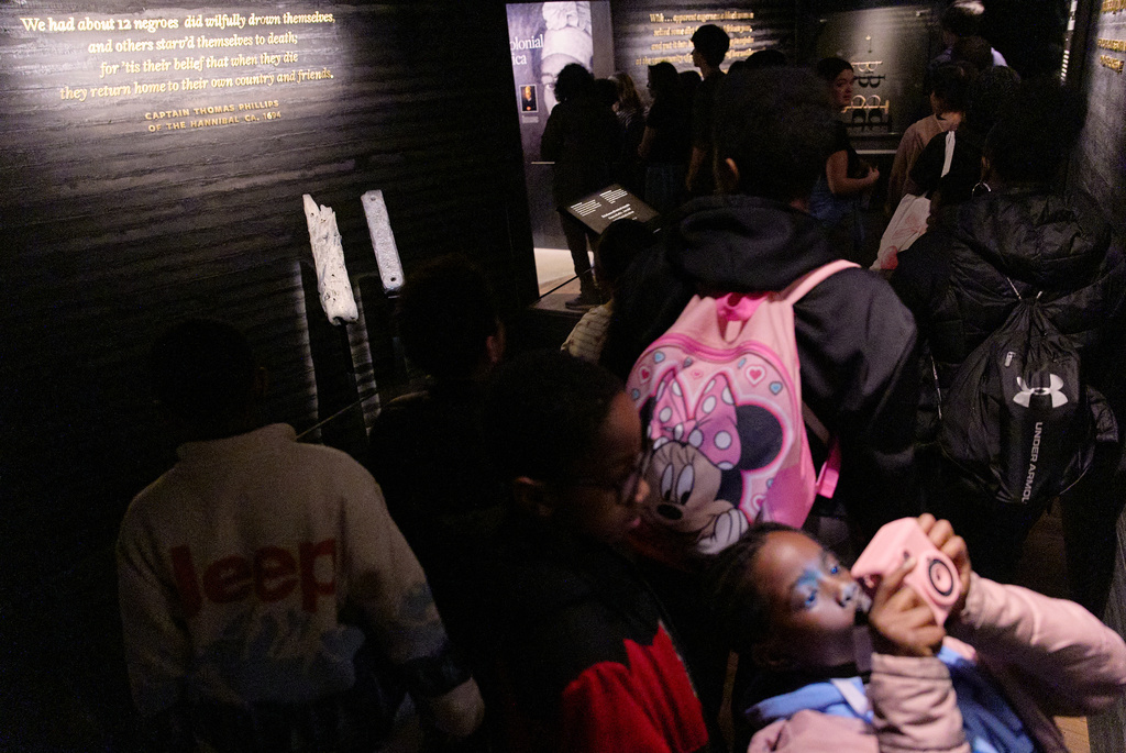 School children visit the National Museum of African American History and Culture's Middle Passage exhibit, including a wooden timber, the artifact at back left, from the slave ship, the São José-Paquete de Africa, Friday, March 6, 2026, in Washington. (AP Photo/Jacquelyn Martin)