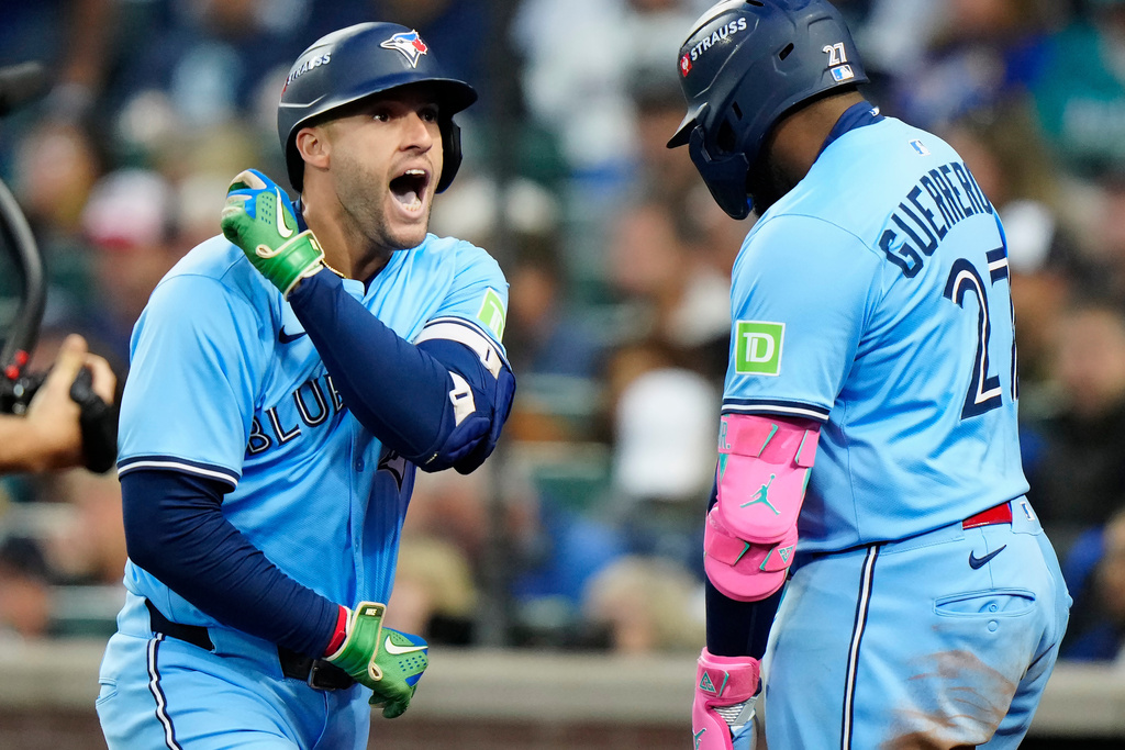 Toronto Blue Jays' George Springer (4) celebrates with Vladimir Guerrero Jr. (27) after hitting a solo home run against the Seattle Mariners during fourth inning Game 3 American League Championship Series baseball action in Seattle on Wednesday, Oct. 15, 2025. (Frank Gunn/The Canadian Press via AP)