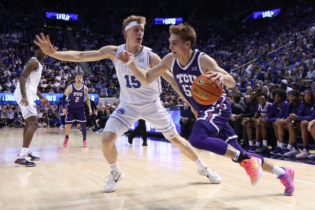 TCU guard Tanner Toolson, right, drives to the basket against BYU guard Richie Saunders (15) during the second half of an NCAA basketball game, Wednesday, Jan. 14, 2026, in Provo, Utah. (AP Photo/Rob Gray)