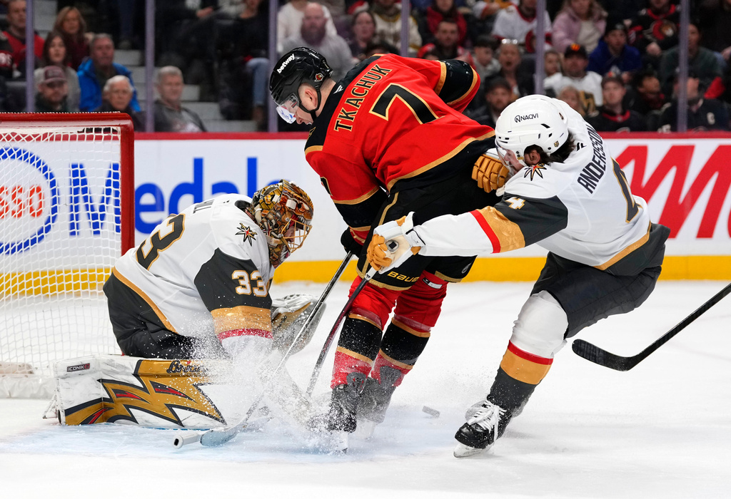 Ottawa Senators' Brady Tkachuk (7) looks for the rebound in front of Vegas Golden Knights goaltender Adin Hill (33) as Rasmus Andersson (4) defends, during the second period of an NHL hockey game in Ottawa, Sunday, Jan. 25, 2026. (Justin Tang/The Canadian Press via AP)