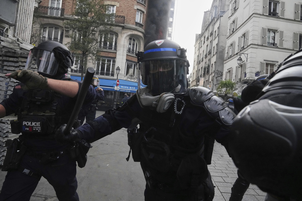 Riot police officers evacuate the surrounding area of a burning restaurant during the « Bloquons Tout » (Block Everything) protest movement in Paris, France, Wednesday, Sept. 10, 2025. (AP Photo/Thibault Camus)