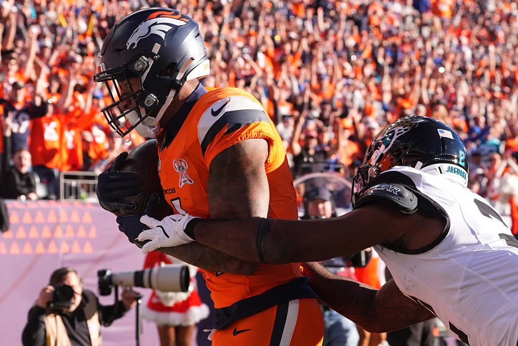 Denver Broncos wide receiver Courtland Sutton makes a catch to score a touchdown against Jacksonville Jaguars cornerback Jourdan Lewis during the first half of an NFL football game in Denver, Sunday, Dec. 21, 2025. (AP Photo/David Zalubowski)