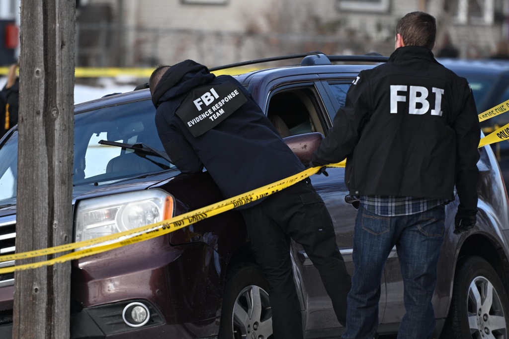 Law enforcement officers attend to the scene of the shooting involving federal law enforcement agents, Wednesday, Jan. 7, 2026, in Minneapolis. (AP Photo/Tom Baker)