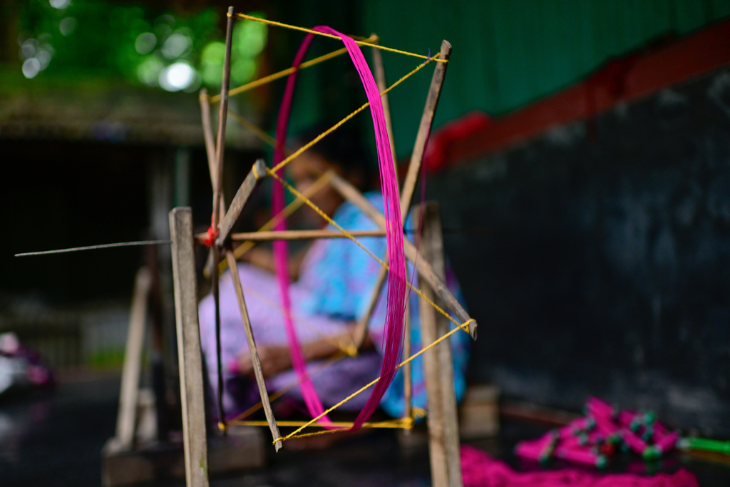 A weaver uses a spinning wheel to make yarn to be used in the making of Tangail sarees at a workshop in Tangail District, Bangladesh, Nov. 5, 2025. (AP Photo/Mahmud Hossain Opu)