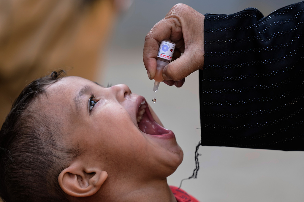 A health worker administers a polio vaccine to a child at a neighbourhood in Karachi, Pakistan, Monday, Monday, Dec. 15, 2025. (AP Photo/Fareed Khan)