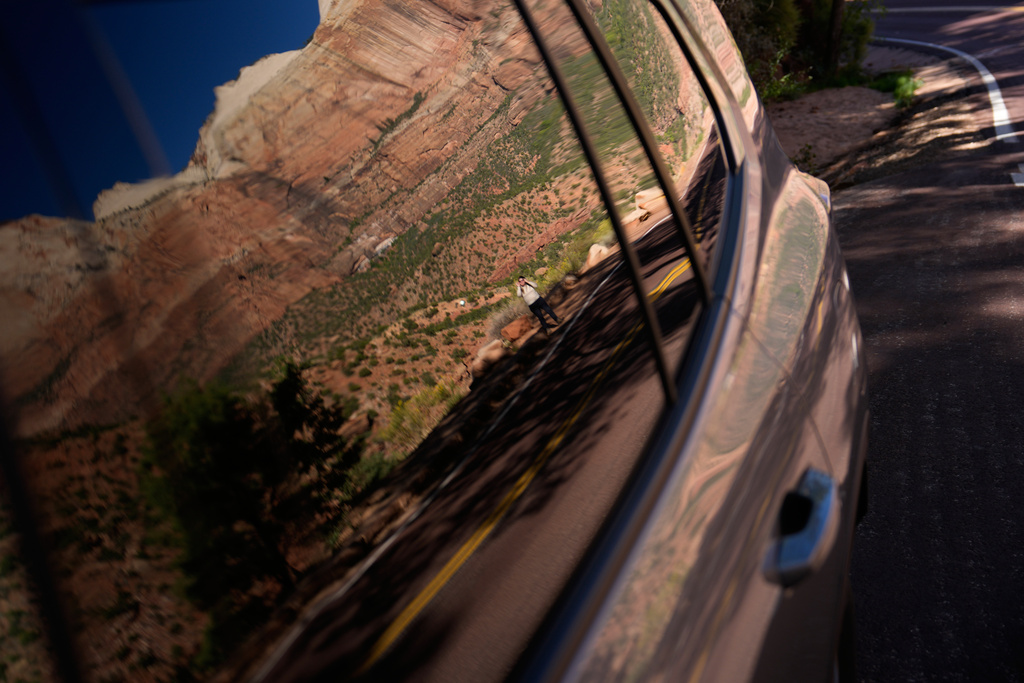 A person is reflected in a window while visiting Zion National Park, Wednesday, Oct. 1, 2025, near Springdale, Utah. (AP Photo/John Locher)