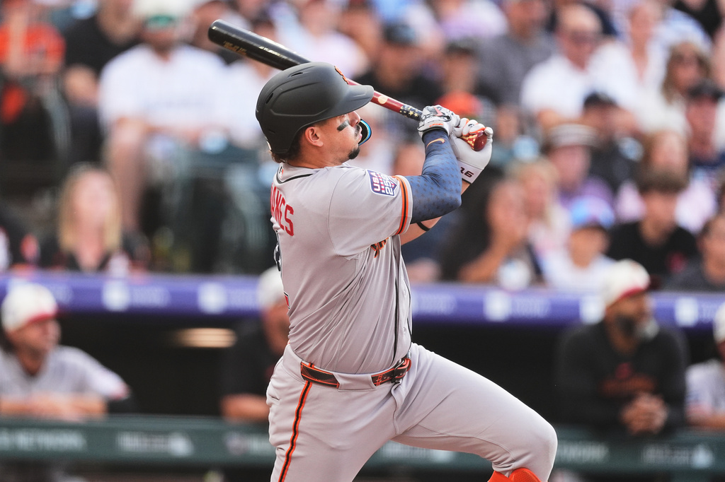 San Francisco Giants'Willy Adames follows the flight of his two-run double off Colorado Rockies starting pitcher Sean Sullivan in the first inning of a baseball game Saturday, July 4, 2026, in Denver. (AP Photo/David Zalubowski)