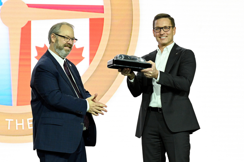 North American Car and Truck of the Year Board Treasurer John Vincent, left, presented the North American Car of the Year award to Dodge Brand Chief Executive Officer, Stellantis North America, Matt McAlear for the Dodge Charger, Wednesday, Jan. 14, 2026, in Detroit. (AP Photo/Jose Juarez)