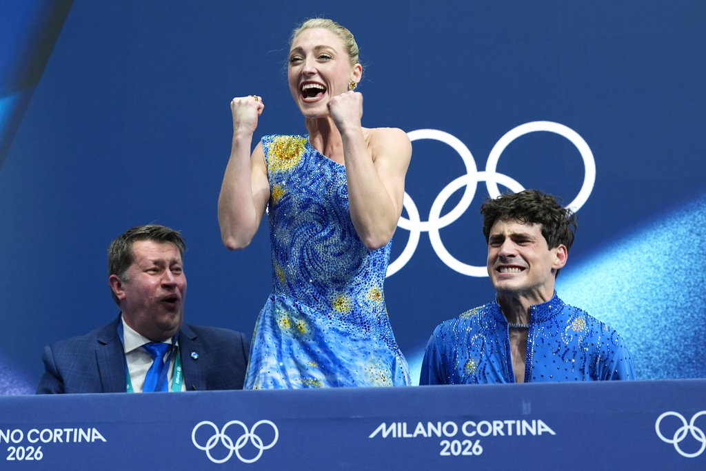 Piper Gilles, center, and Paul Poirier, right, of Canada react to their scores after competing during the ice dancing free skate in figure skating at the 2026 Winter Olympics, in Milan, Italy, Wednesday, Feb. 11, 2026. (AP Photo/Stephanie Scarbrough)