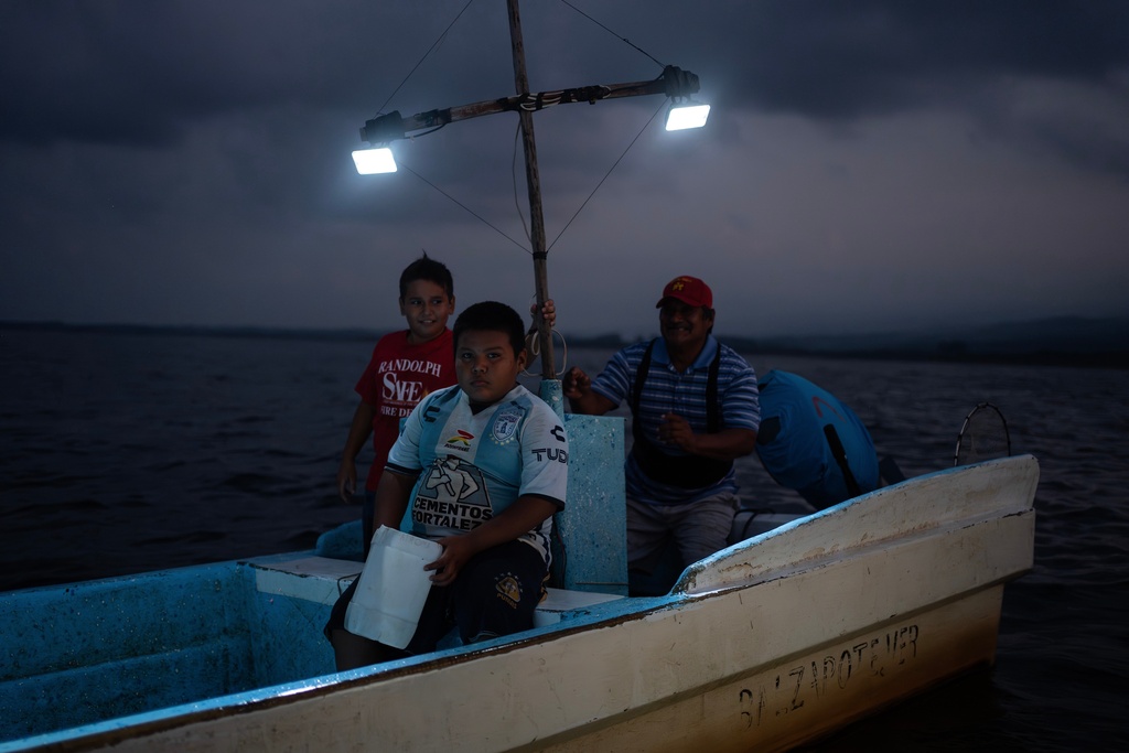 FILE - Fisherman Pancho Contreras sails at sea with young fishermen as night falls near Los Arrecifes, Mexico, Oct. 26, 2025. (AP Photo/Felix Marquez, File)