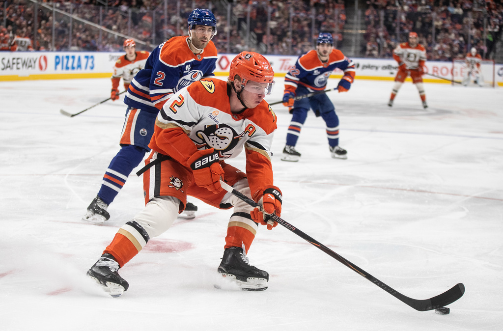 Anaheim Ducks' Jackson LaCombe, front,is chased by Edmonton Oilers' Evan Bouchard, behind, during first-period NHL hockey game action in Edmonton, Alberta, Monday, Jan. 26, 2026. (Jason Franson/The Canadian Press via AP)