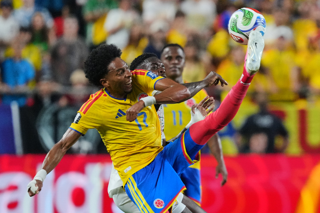 Colombia's Johan Mojica (17) kicks the ball over Ghana's Inaki Williams for the ball during the World Cup round of 32 soccer match between Colombia and Ghana in Kansas City, Mo., Friday, July 3, 2026. (AP Photo/Ed Zurga)
