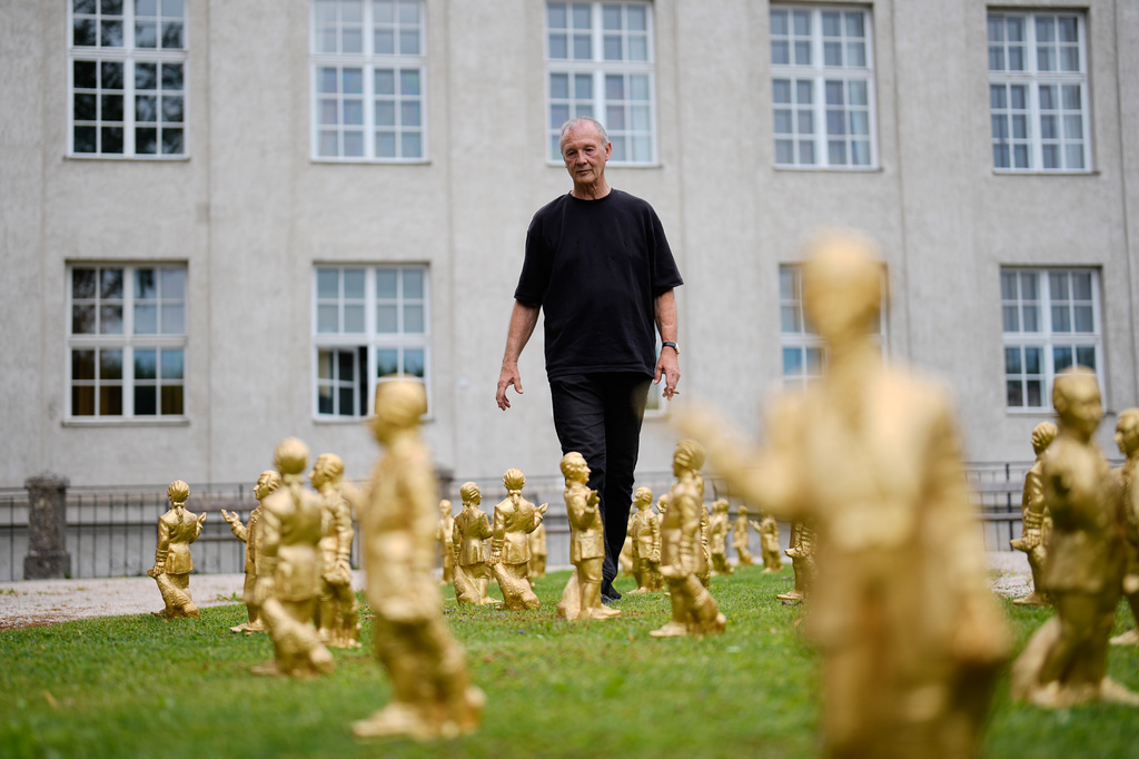 German artist Ottmar Hoerl from Nuremberg walks through his installation comprising of 400 gold colored plastic Mozart sculptures for the 270th birthday of composer Wolfgang Amadeus Mozart in Salzburg, Austria, Wednesday, July 15, 2026. (AP Photo/Matthias Schrader)