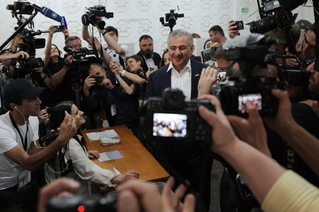 Russian-Armenian tycoon Samvel Karapetyan, center, speaks to the media after voting at a polling station during parliamentary election in Yerevan, Armenia, Sunday, June 7, 2026. (AP Photo/Anthony Pizzoferrato)