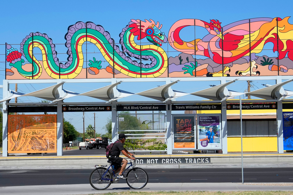 A cyclist rides past a Phoenix Light Rail station, May 20, 2026, in Phoenix. (AP Photo/Ross D. Franklin)