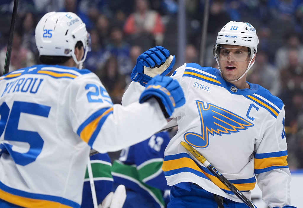 St. Louis Blues' Brayden Schenn, right, and Jordan Kyrou, left, celebrate after Schenn's goal against the Vancouver Canucks during the second period of an NHL hockey game in Vancouver, British Columbia, Monday, Oct. 13, 2025. (Darryl Dyck/The Canadian Press via AP)