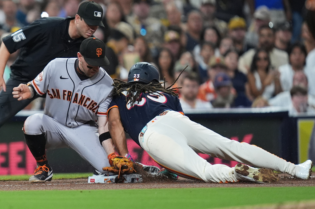 San Diego Padres' Fernando Tatis Jr., right, steals third base as San Francisco Giants third baseman Christian Koss is late with the tag during the fourth inning of a baseball game Friday, July 31, 2026, in San Diego. (AP Photo/Gregory Bull)